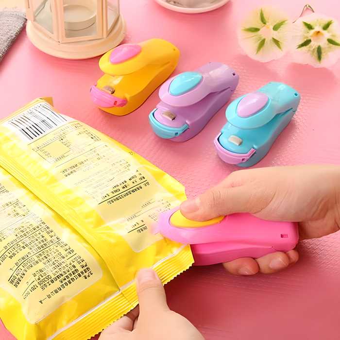 Portable mini sealing machine in use to reseal a bag of chips, keeping food fresh. Colorful handheld kitchen gadget.
